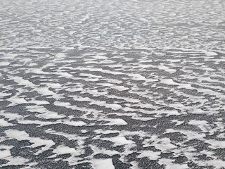 Aerial drone top view. Frosty pattern drawing on the river. Cloudy frosty winter morning.