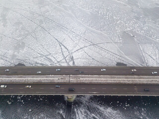 Aerial drone view. Metro bridge in Kiev among frosty patterns on the river. Cloudy frosty winter morning.