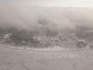 Fog over a frozen river in Kiev. Aerial drone view. Foggy winter morning.