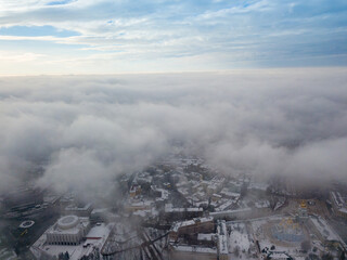 Fototapeta premium Fog over the snowy Kiev city. Aerial drone view. Foggy winter day.