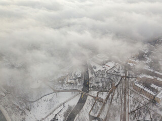 Fog over the snowy Kiev city. Aerial drone view. Foggy winter day.