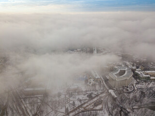 Fog over the snowy Kiev city. Aerial drone view. Foggy winter day.