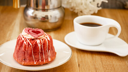 Valentine dessert. Pink raspberry and strawberry sugar glazed muffin, heart decoration, cake espresso coffee for breakfast or dessert  Differential focus, close up, macro. 