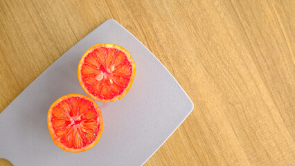 Slice of red blood orange on a wooden board