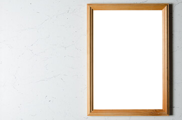 An empty wooden photo frame on a textured gray wall.