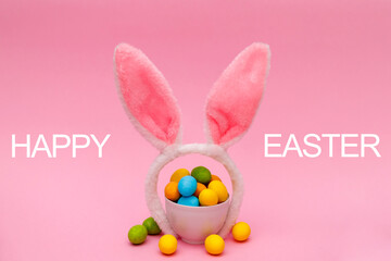 Easter bunny. Happy Easter holiday background concept.Flat lay colorful bunny egg with accessory to celebration on modern rustic pink pastel paper at home office desk.