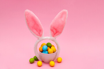Fototapeta premium Easter bunny. Happy Easter holiday background concept.Flat lay colorful bunny egg with accessory to celebration on modern rustic pink pastel paper at home office desk.