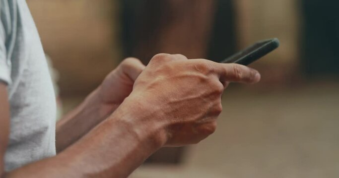 Male Hands Texting Message on Mobile Smart Phone for Communication with Friends and Chatting on Social Network Online.Close up Man Using Smartphone Outside on Blurred Background