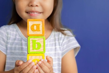 A happy little kid learning abc with blocks. Children learning. - obrazy, fototapety, plakaty