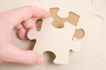 Man's hand attaches the missing piece of the puzzle.