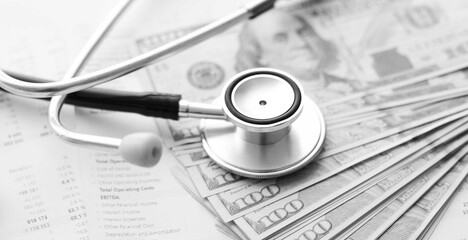 Stethoscope, calculator and money cash on medical data. Concept of health care costs or medical insurance