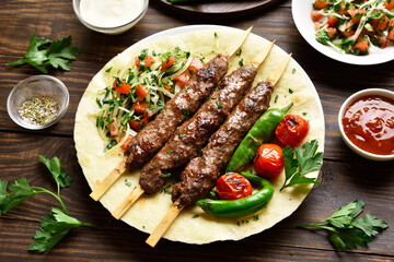 Turkish Adana Kebab with fresh vegetables on flatbread