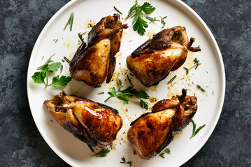 Roasted quails on white plate