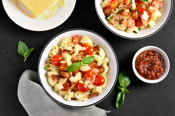 Pasta with bacon, tomato, parmesan cheese and basil leaves