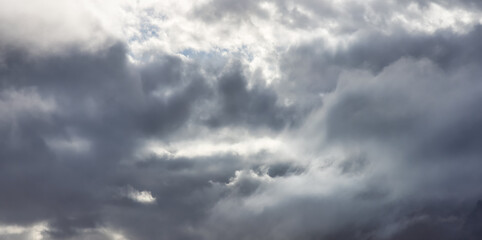 Beautiful Panoramic View of dark cloudscape during dramatic sunset. Art Render. Taken in British Columbia, Canada.