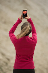 Ragazza che fotografa un tramonto in pieno giorno