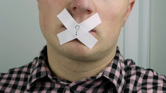  A man's mouth is closed, a man with his lips sealed with sticky tape, a young guy with a sticky plaque over his mouth