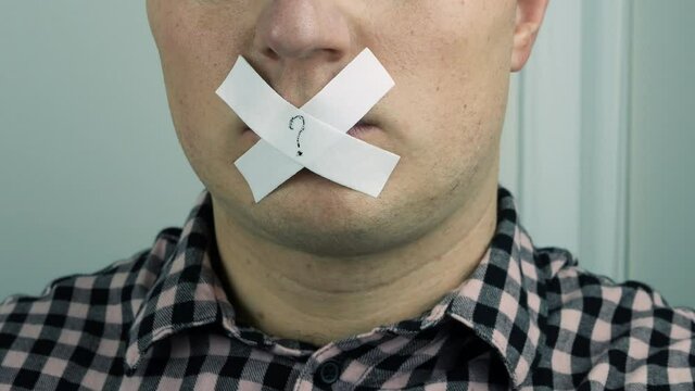 The man's mouth is closed, the man's lips are sealed with tape, the young guy's mouth is sealed with tape. Portrait of a man. 