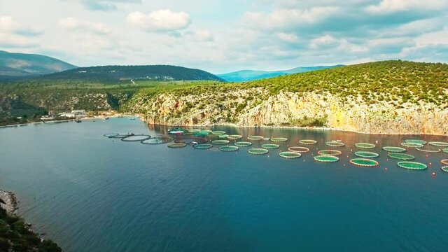 Beautiful scenery mediterranean bay fish farm floating net pools aerial view sea blue water mountains coastal skyline seafood industry