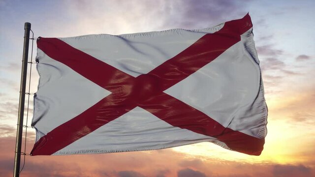 Flag of Alabama waving in the wind against deep beautiful sky at sunset