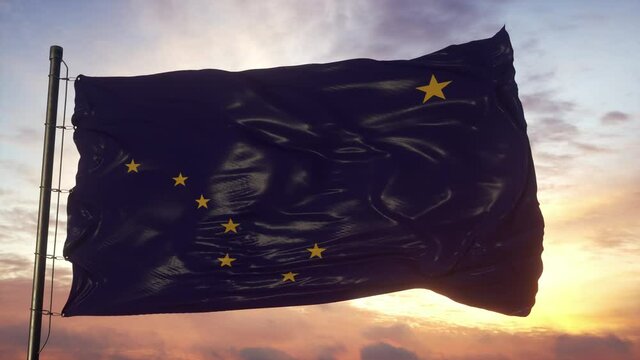 Flag of Alaska waving in the wind against deep beautiful sky at sunset