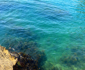 Obraz premium Turquoise sea crystal clear water, rippled waves of Mediterranean sea.
