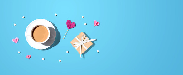 A cup of coffee with a gift box and hearts - flat lay