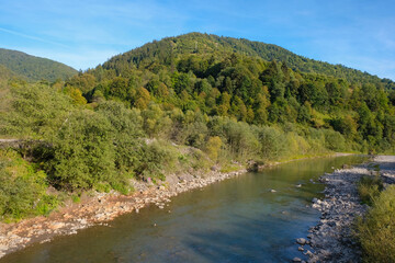 Fototapeta na wymiar Beautiful mountain river Tisza, Ukraine with plastic-clogged shores. Ecological problems concept.