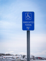 Handicapped Parking Only Sign on Blue Cloudy Sky Background