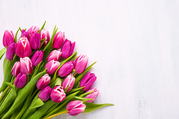 Bouquet of bright pink tulips on a white background. Flat lay, copy space