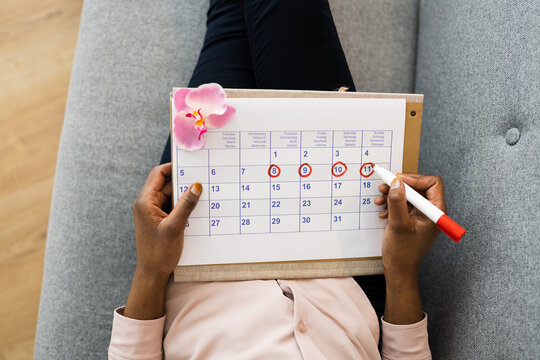 African Woman Using Menstrual Cycle Calendar