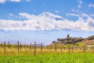 Fototapeta na wymiar Awe-Inspiring medieval Khor Virap monastery in front of Mount Ararat viewed from Yerevan, Armenia. This snow-capped dormant compound volcano described in the Bible as the resting place of Noah's Ark.