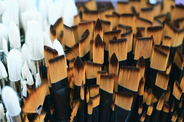 Stunning and sophisticated paint brushes in the shop. Natural squirrel brushes of different forms and sizes. Artist's tools on the blurred background. Black and white brushes.