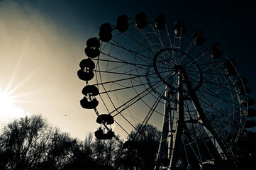 Monochrome construction of the Ferris wheel in the abandoned park. Industrial composition of metal architecture beauty with winter sun rays. 