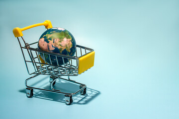 planet earth in supermarket trolley, online shopping. Concepth photo of Earth Day