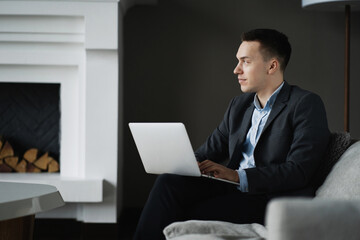 The economist is a man in a business suit sitting in a modern office. the consultant prints a text message on the tablet. social network chat with partners.