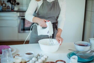 Young beautiful woman bakes a cake. Sweets. Confectionery.
