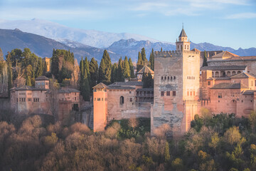 Fototapeta na wymiar Classic view with sunset or sunrise golden light of Charles V Palace, the iconic Alhambra and Sierra Nevada Mountains from Mirador de San Nicolas in the albaicin old town of Granada, Andalusia, Spain.