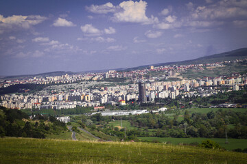 Fototapeta na wymiar Landscape of a city from the hill view during summer time and the meadow, very beautiful view of a big city.