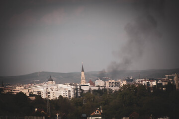 Landscape of city zoom in on the church, smoke above the city