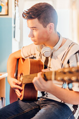 Obraz premium Teenage boy taking guitar lessons online. Technology concept.