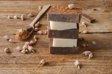 Bars of homemade black and white chocolate soap, on an old wooden background