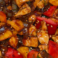 Braised chicken with onion, sweet pepper and sesame seeds in a dark sauce. 