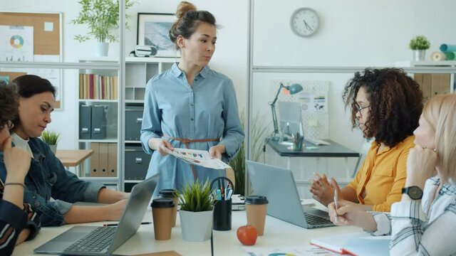 Slow motion of angry mixed race woman boss blaming group of workers for bad work in office. Negative emotions and stress in workplace concept.