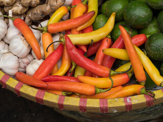 Vietnam, Hanoi, Old Quarter. Peppers, garlic, limes, and ginger in basket at market.