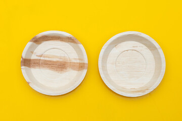 Betel palm leaf plates on yellow background.