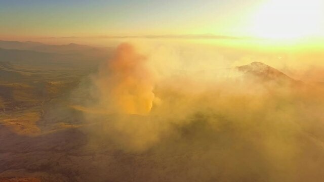Mountain forest fire yellow smoke wide scenery sun sky horizon burning sunset skyline aerial backward motion environmental disaster