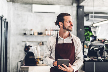 Portrait of barista man small business owner standing with tablet computer and receive order from...