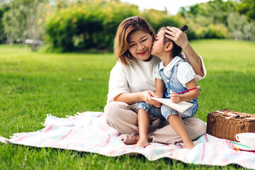 Portrait of happy asian grandmother and little asian cute girl enjoy relax in summer park.Young girl with their laughing grandparents smiling together.Family and togetherness