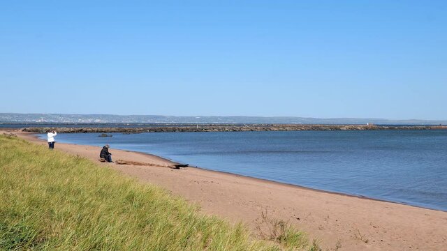 The lake shore and ship channel at Wisconsin Point in Superior, with the blue water of Great Lake Superior and Duluth, Minnesota in the distance, on a sunny day.